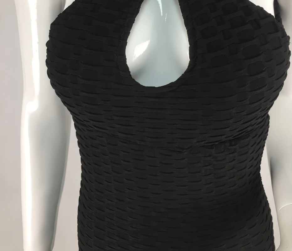 Close-up of black textured open-back yoga jumpsuit made from breathable nylon, featuring a stylish cut-out design on mannequin torso.